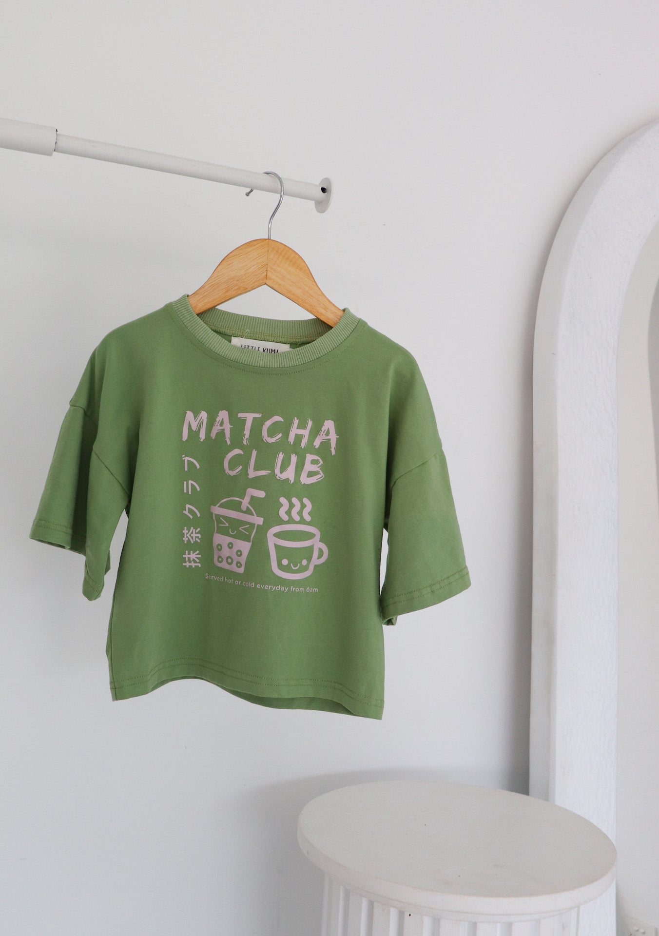 hanging oversized green t-shirt with a pink matcha club logo